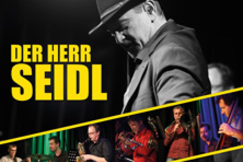 Das Cover zeigt „Der Herr Seidl“ mit einer Band in einer Live-Performance.