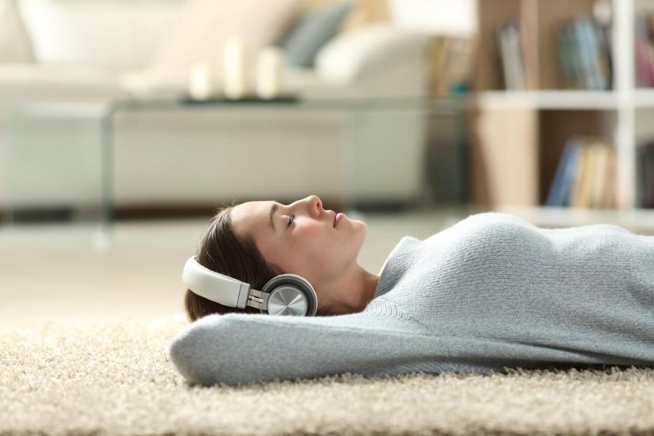 Relaxed woman listening to music with headphones at home