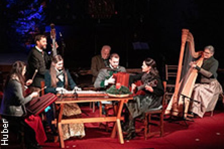 Eine Gruppe von Musikern spielt traditionelle Instrumente auf einer Bühne.