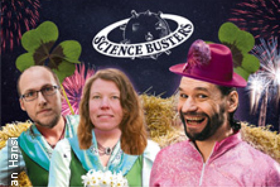 Die Science Busters präsentieren sich vor einem festlichen Hintergrund mit Feuerwerk und Glücksklee.