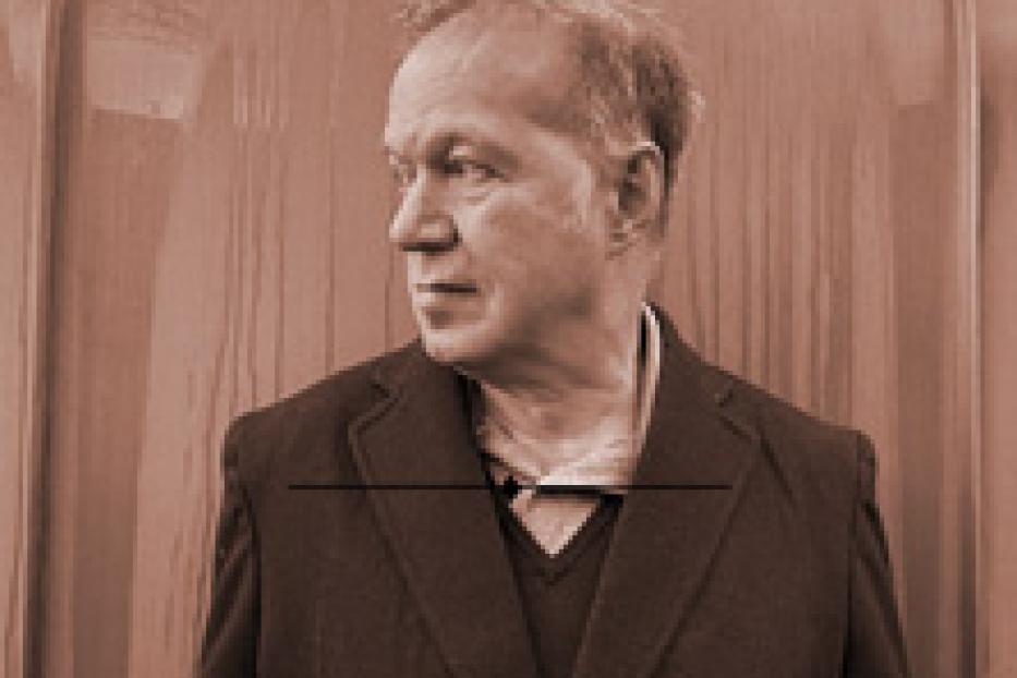 Ein Mann mit dunkler Jacke blickt nach links.