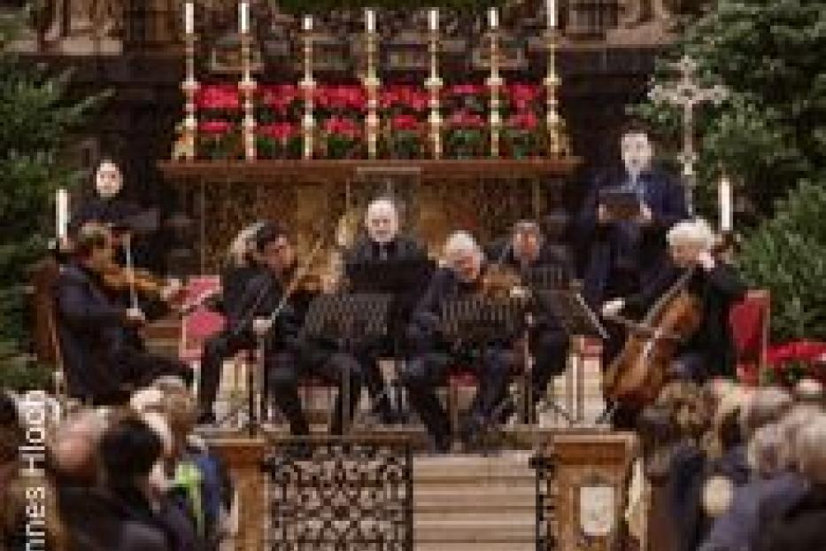 Ein Orchester spielt in einer Kirche vor einem Publikum.