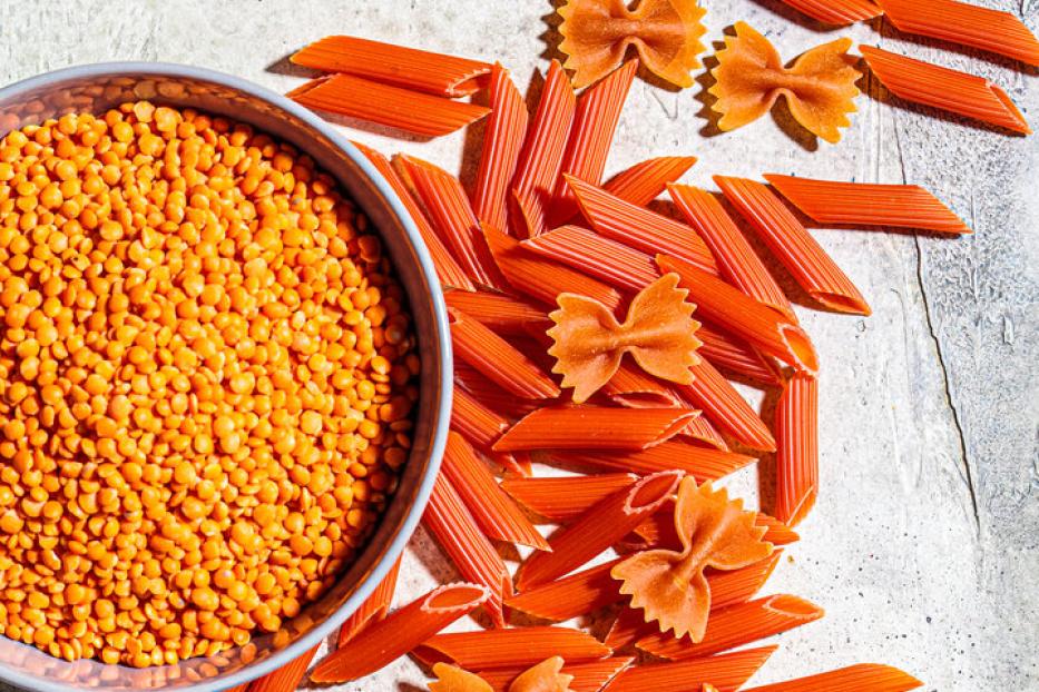 Rote Linsen und rote Nudeln in Form von Penne und Farfalle.