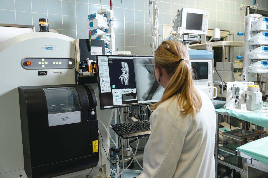Szene aus einem Labor, eine Wissenschafterin blickt auf eine Röntgenaufnahme eines Kniegelenks: Forschung zu neuen Verfahren für Knie-OPs ist ein Bereich des Boltzmann-Instituts für Traumatologie.