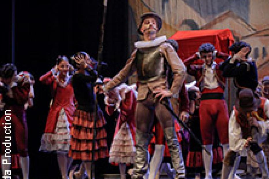 Eine Bühnenszene mit Tänzern in Kostümen, möglicherweise aus einer Aufführung von Don Quijote.