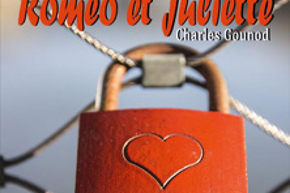 Ein rotes Vorhängeschloss mit einem Herz vor einem Opernplakat von „Roméo et Juliette“.