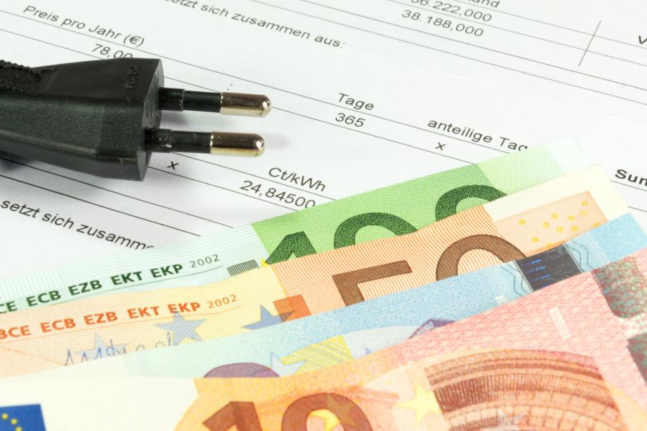 Euroscheine und Gerätestecker auf einer Stromrechnung