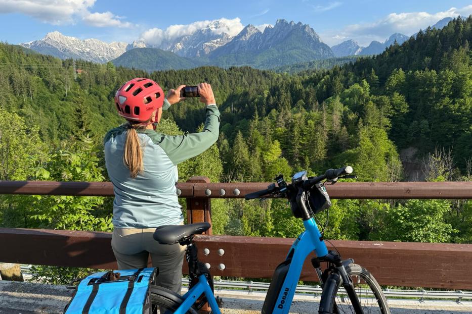 Frau mit Fahrrad fotografiert Berge
