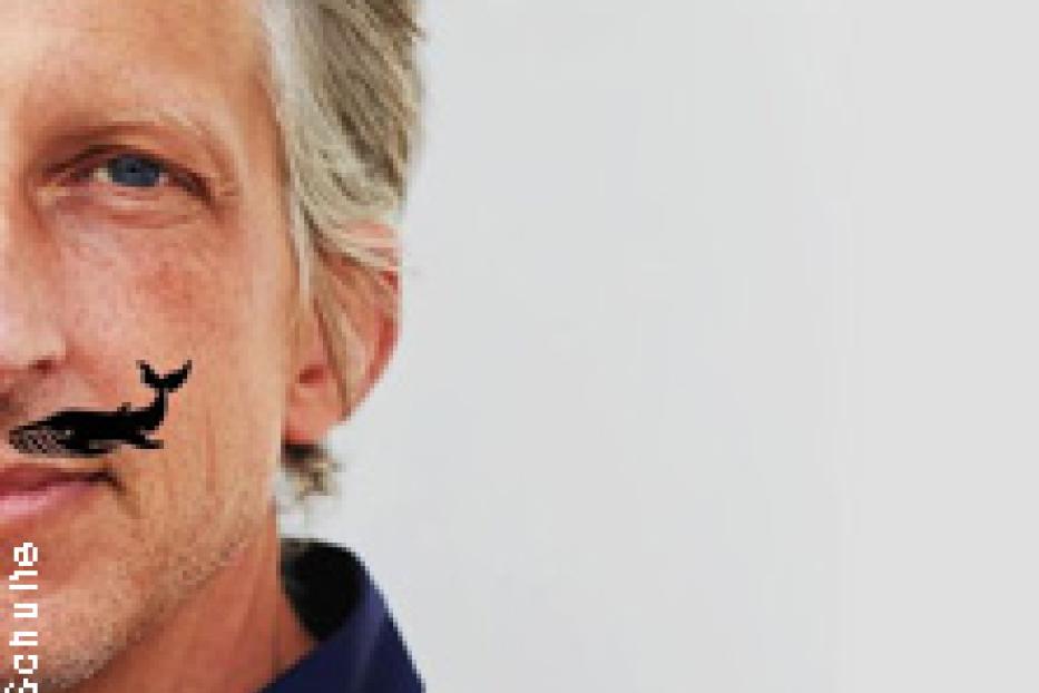 Porträt eines Mannes mit einer kleinen Wal-Zeichnung auf seiner Wange.