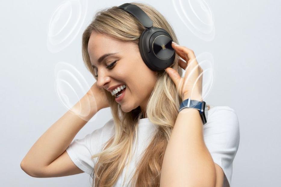 Eine Frau hat Kopfhörer auf und genießt es Musik zu hören.