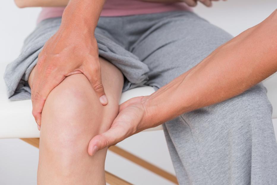 Doctor examining his patient knee