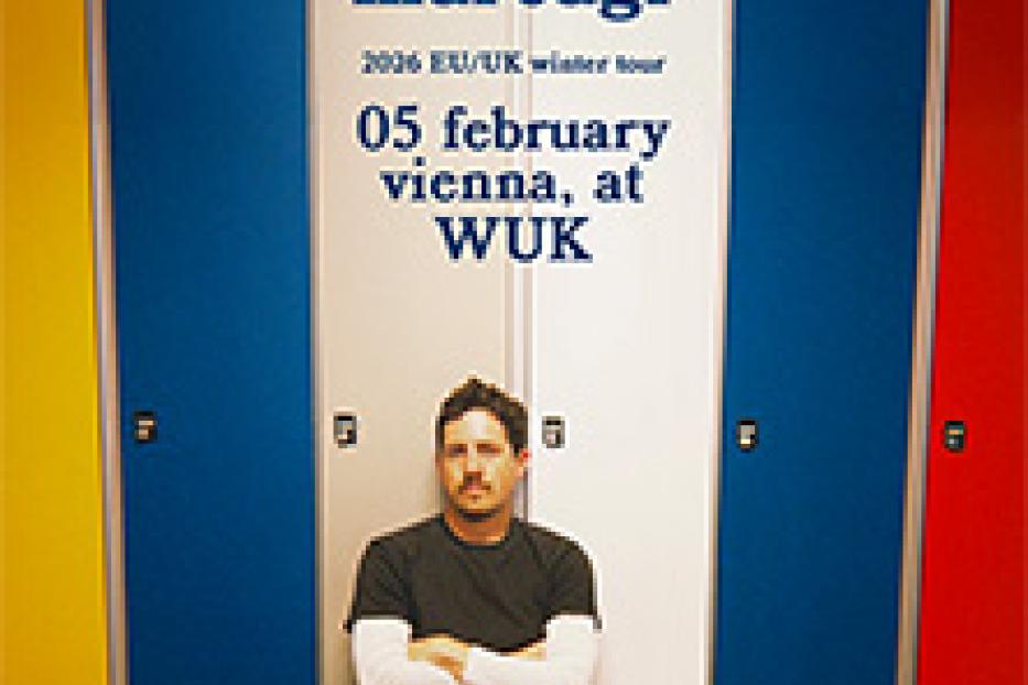 Michael Marcagi posiert vor farbigen Spinden für seine Wintertour 2026 in Wien.