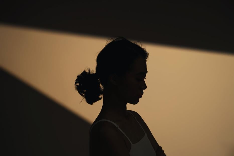Schatten-Foto einer jungen, nachdenklichen Frau.
