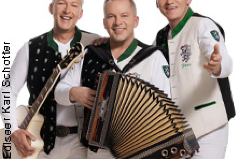 Die Edlseer posieren mit Gitarre und Akkordeon vor einem weißen Hintergrund.