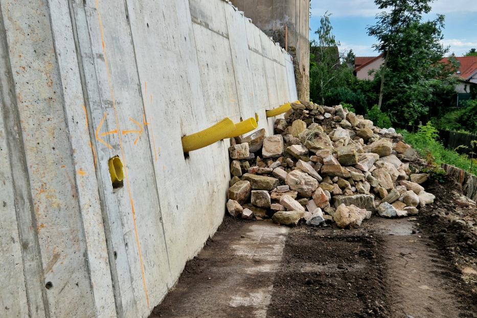 Hanggrundstück mit Mauer aus Beton und Drainage-Abläufen. 
