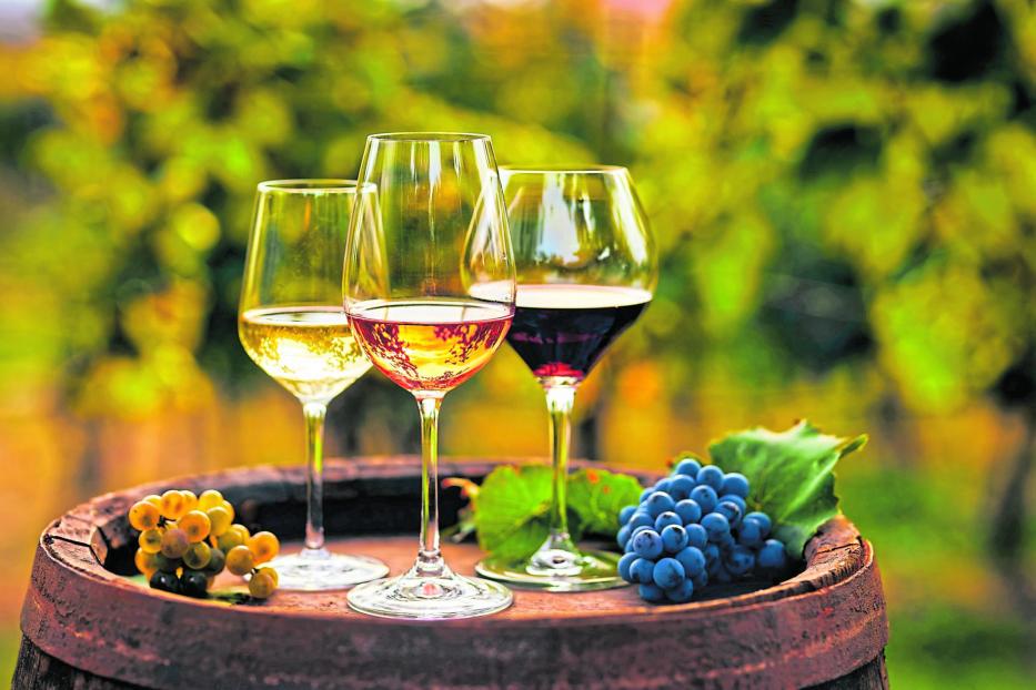 Three glasses of white, ros?É¬© and red wine and an old wooden barrel, with winery still life