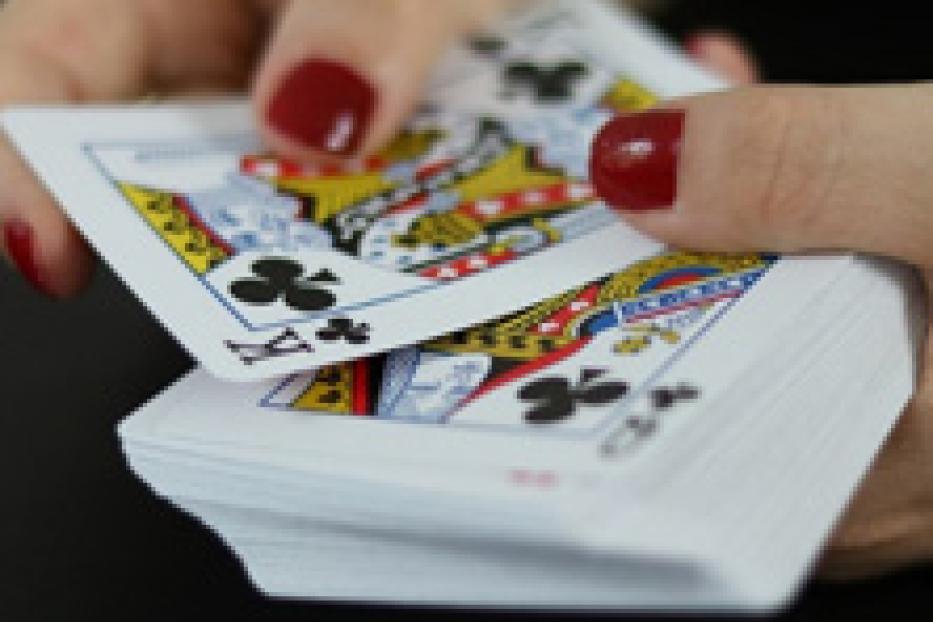 Eine Person mischt einen Stapel Spielkarten.