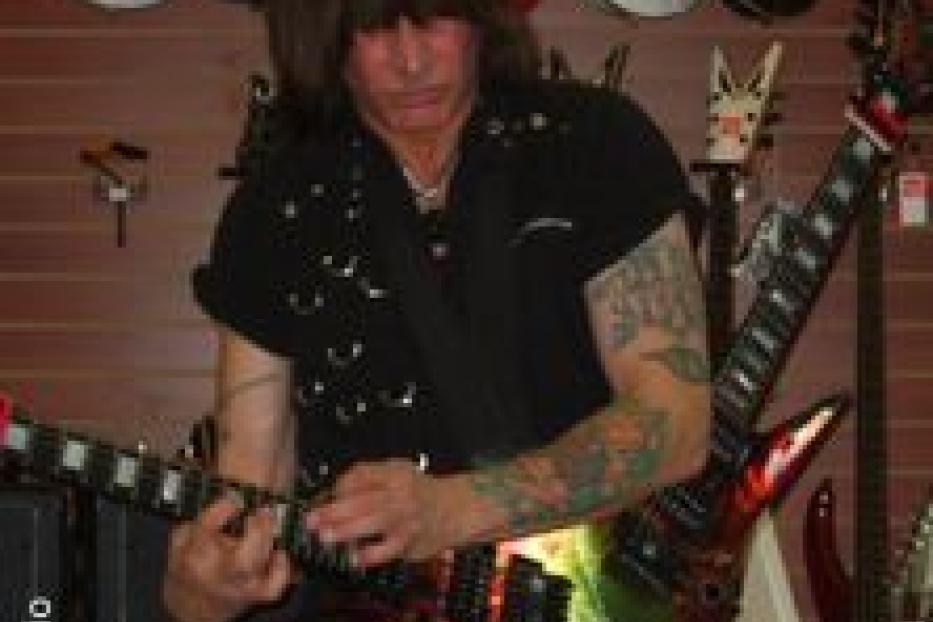 Michael Angelo Batio spielt in einem Musikgeschäft Gitarre.