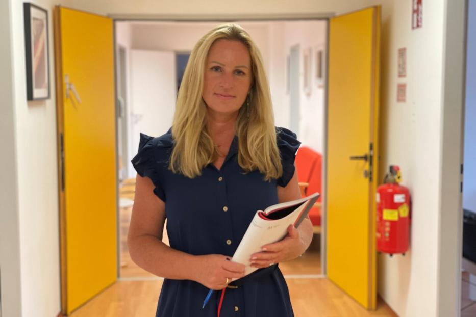 Claudia Holub im Vereinsbüro mit einer Mappe in der Hand.