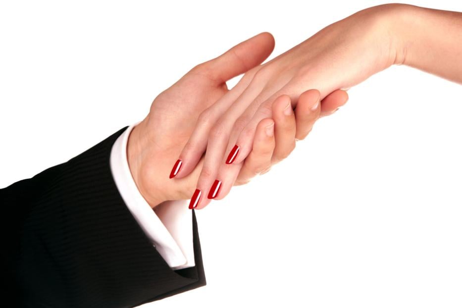 Frauenhand mit roten Fingernägeln liegt in elegante Männerhand