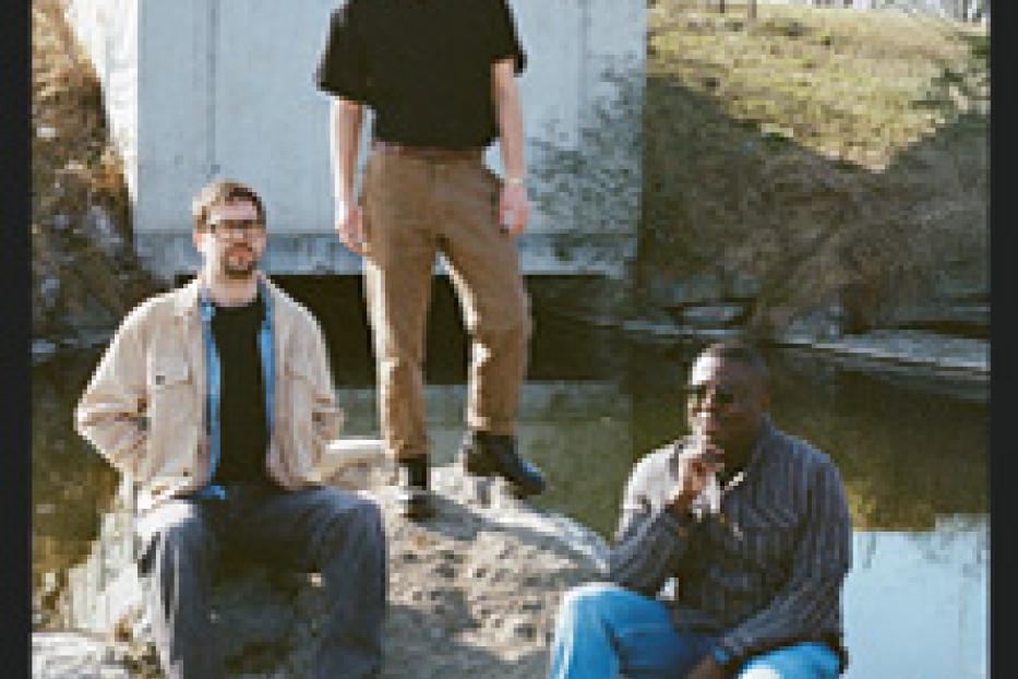 Die Band Sladek posiert vor einem Teich für ein Bandfoto.