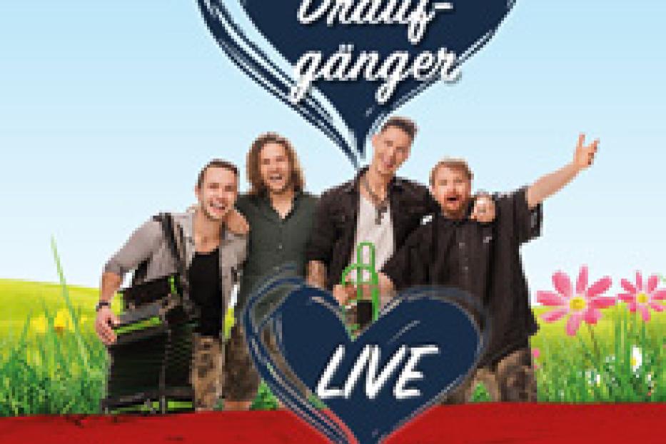 Die Band „Die Draufgänger“ steht vor einer Wiese mit Blumen und dem Schriftzug „Brunn am Gebirge“.