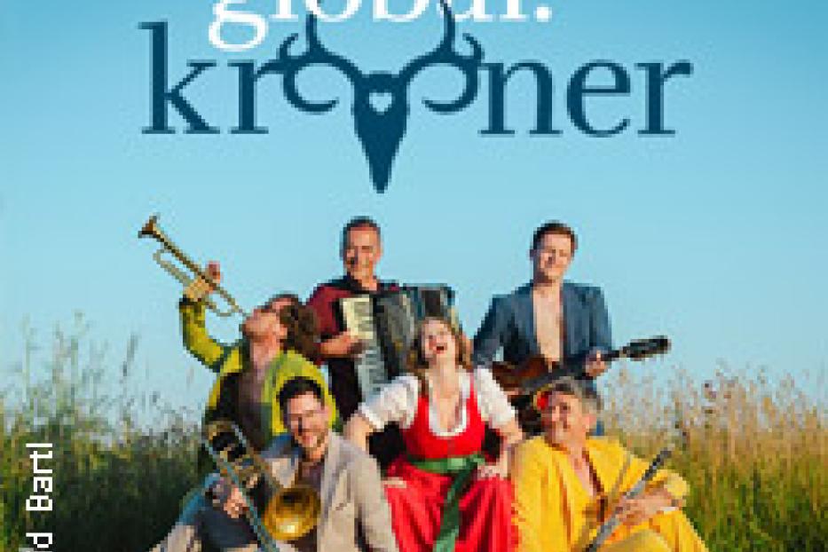 Die Band Global Kryner posiert mit ihren Instrumenten auf einer Landstraße.
