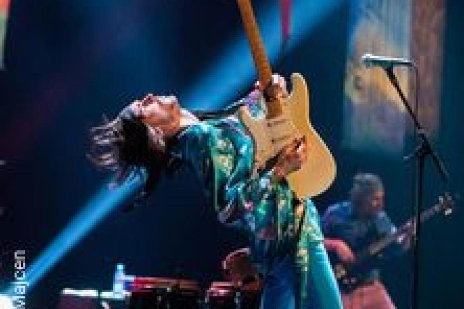 Ein Gitarrist spielt auf der Bühne mit zurückgelehntem Kopf.