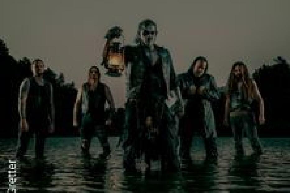 Eine Band steht im Wasser, der Sänger hält eine Laterne in der Hand.