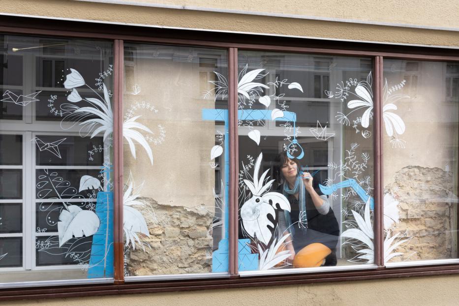 Schaufenster eines Grafikbüros in Wien Hernals. Die Illustratorin Nadine Kappacher zeichent mit Kreidestiften auf das Glas