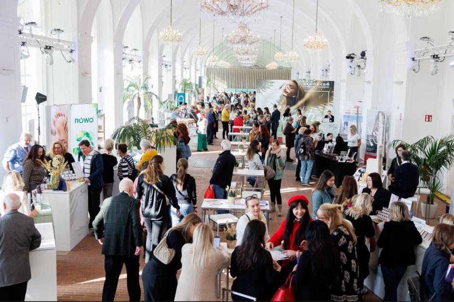 Eine große Gruppe von Menschen in einem weitläufigen Saal.