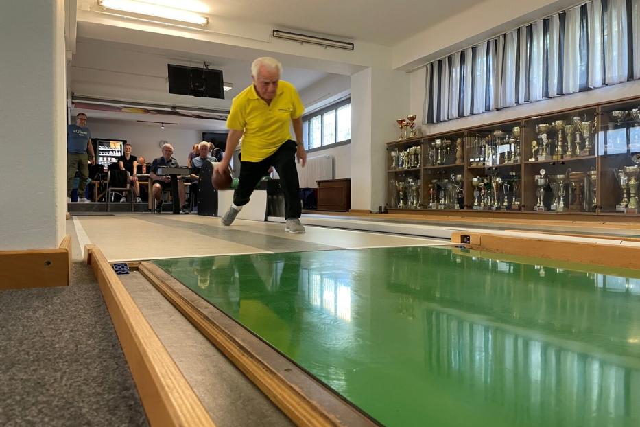 Bruno Wohlmuth im gelben Trikot scheibt eine Kugel auf der Kegelbahn.