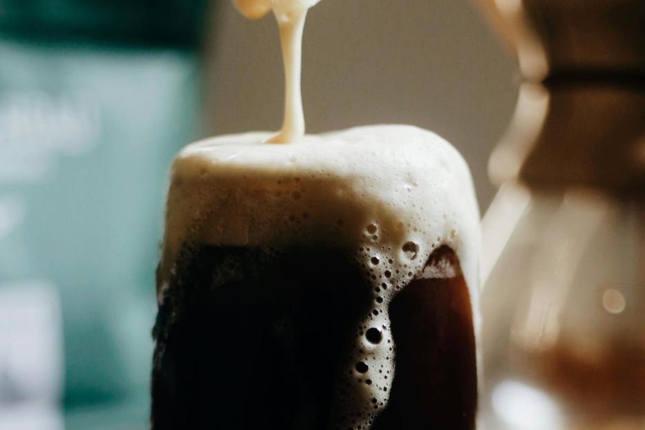 Glas voll Bier schäumt über