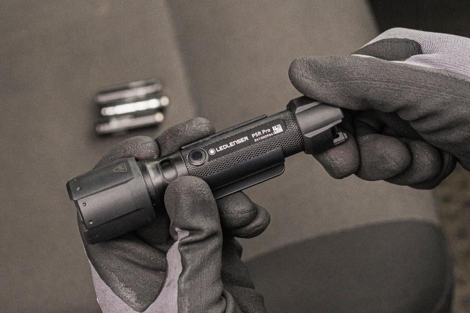 Eine Person mit Handschuhen hält die Taschenlampe P5R Pro von Ledlenser in den Händen.