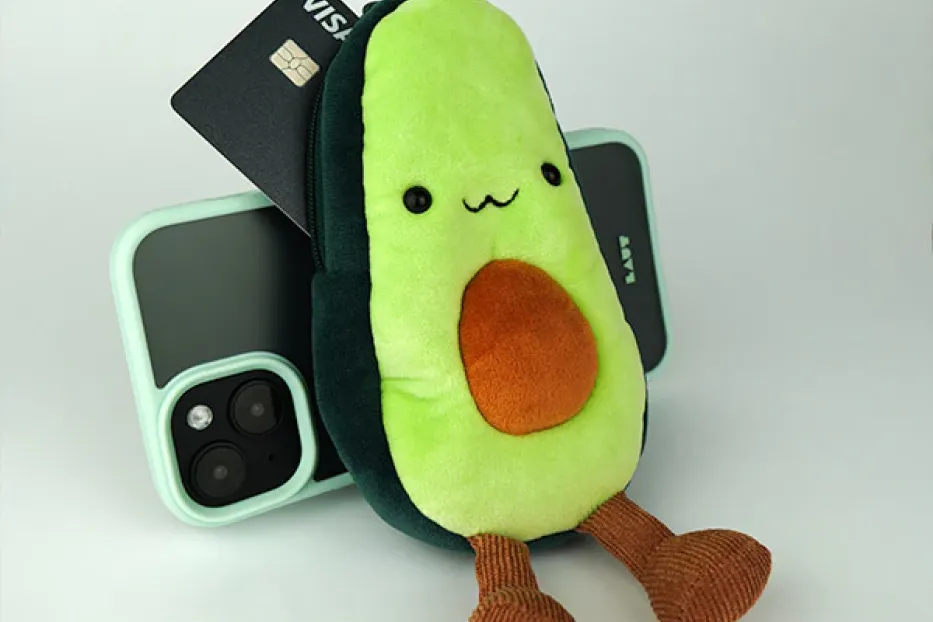 Mamoji Avocado Plüschtier sitzt vor Handy und Kreditkarte 
