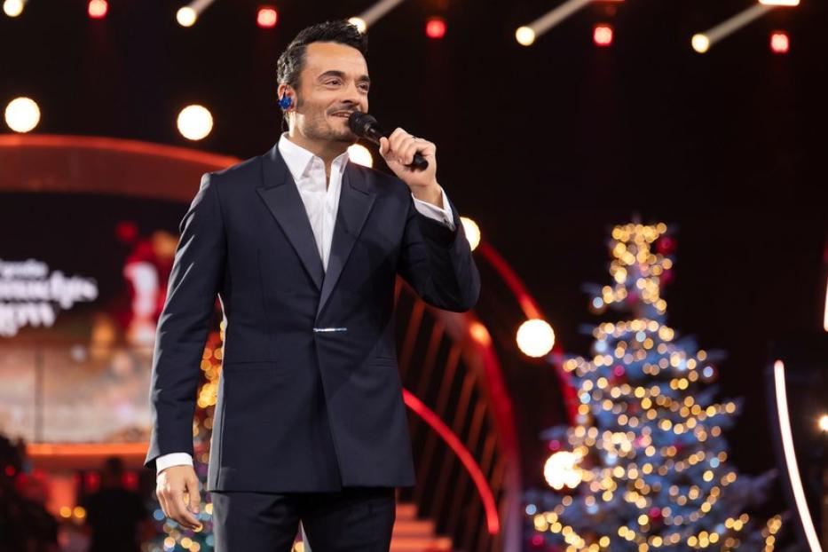 Giovanni Zarrella mit Mikro vor Christbaum im TV-Studio