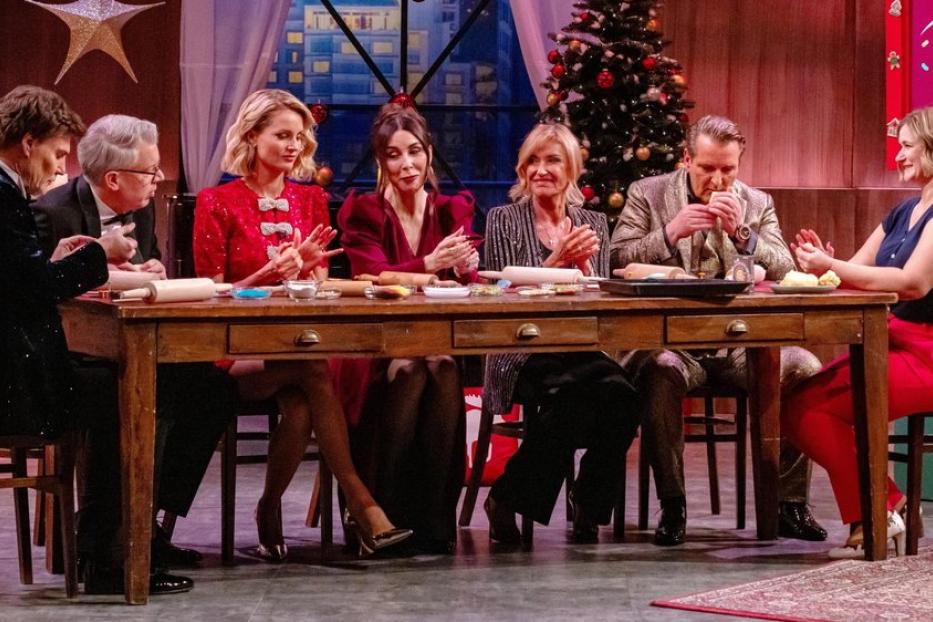 "Die Löwen"-Crew sitzt an einem weihnachtlichen Tisch im Studio