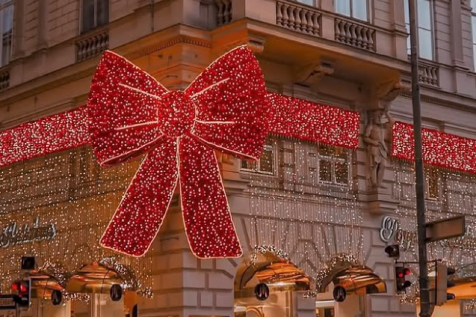 Riesige rote Weihnachtsschleife mit Lichterketten an einem Eckhaus auf der Kärntner Straße.