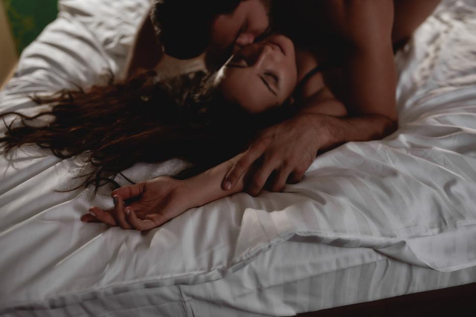 I need your love. Cropped shot of young couple making love in the bed. Passionate man gently kissing beautiful woman on neck with desire