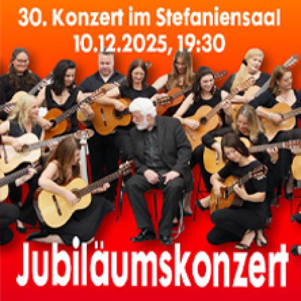 Eine Gruppe von Gitarristen spielt gemeinsam auf der Bühne bei einem Jubiläumskonzert.