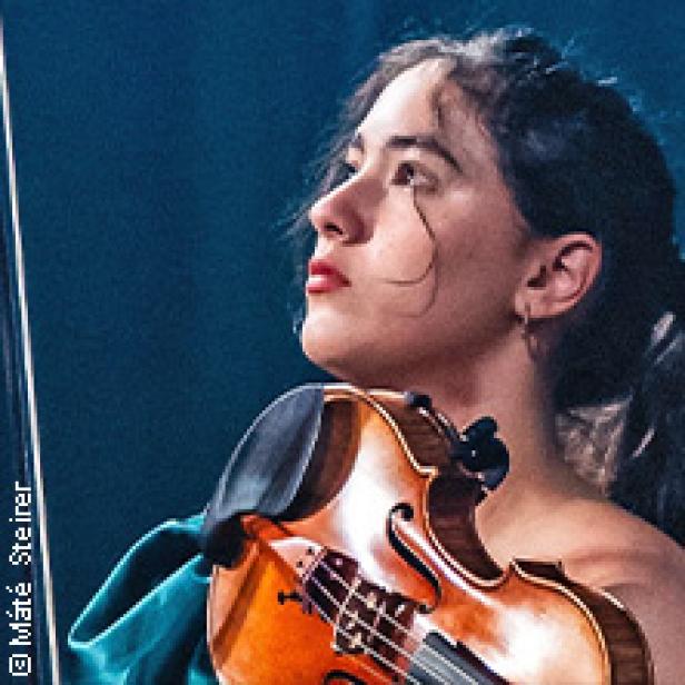 Eine junge Frau spielt Violine, den Kopf leicht zur Seite geneigt.