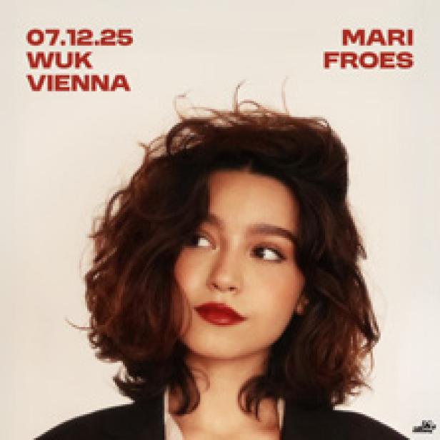 Porträt einer jungen Frau mit dunklen Haaren und rotem Lippenstift vor einem Ankündigungsplakat für Mari Froes in Wien.