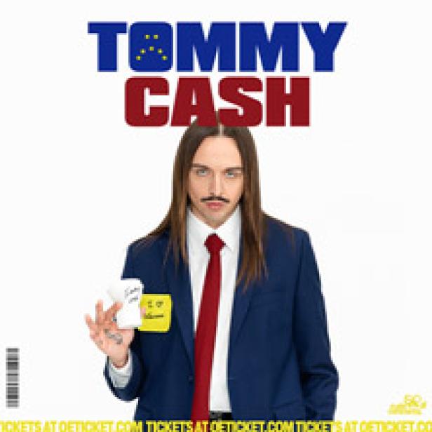 Tommy Cash im Anzug mit EU-Flagge und einem Zettel mit der Aufschrift „I <3 Ukraine“.