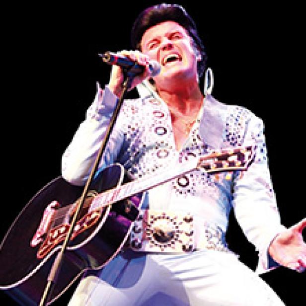 Ein Elvis-Presley-Imitator singt mit Gitarre auf einer Bühne.