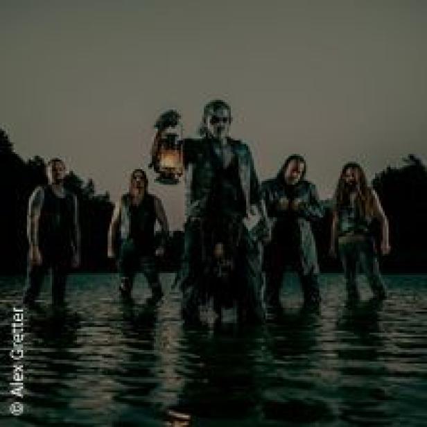 Eine Band steht im Wasser, der Sänger hält eine Laterne in der Hand.
