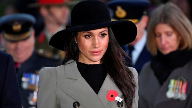 Meghan, Herzogin von Sussex, trägt einen Hut und einen Mantel mit einer Mohnblume.