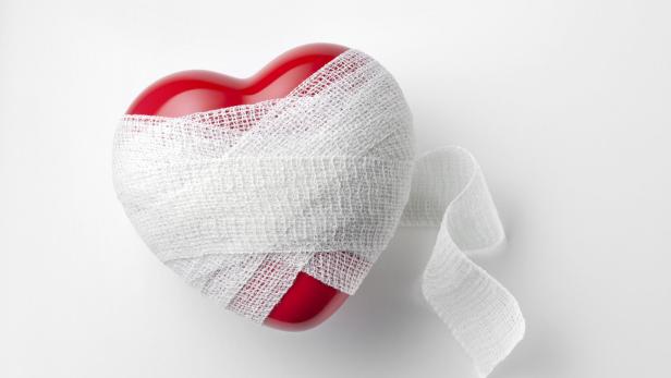 Ein rotes Plastikherz in einer Bandage