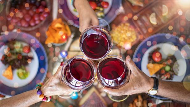 Family dinner for a celebration with red wine and cheers.