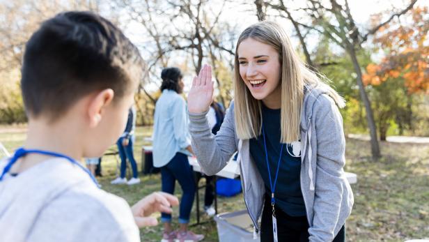 Community outreach volunteer coordinator greets young volunteer