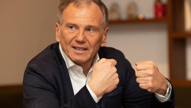 Ein Mann in einem dunklen Sakko gestikuliert mit geballten Fäusten.